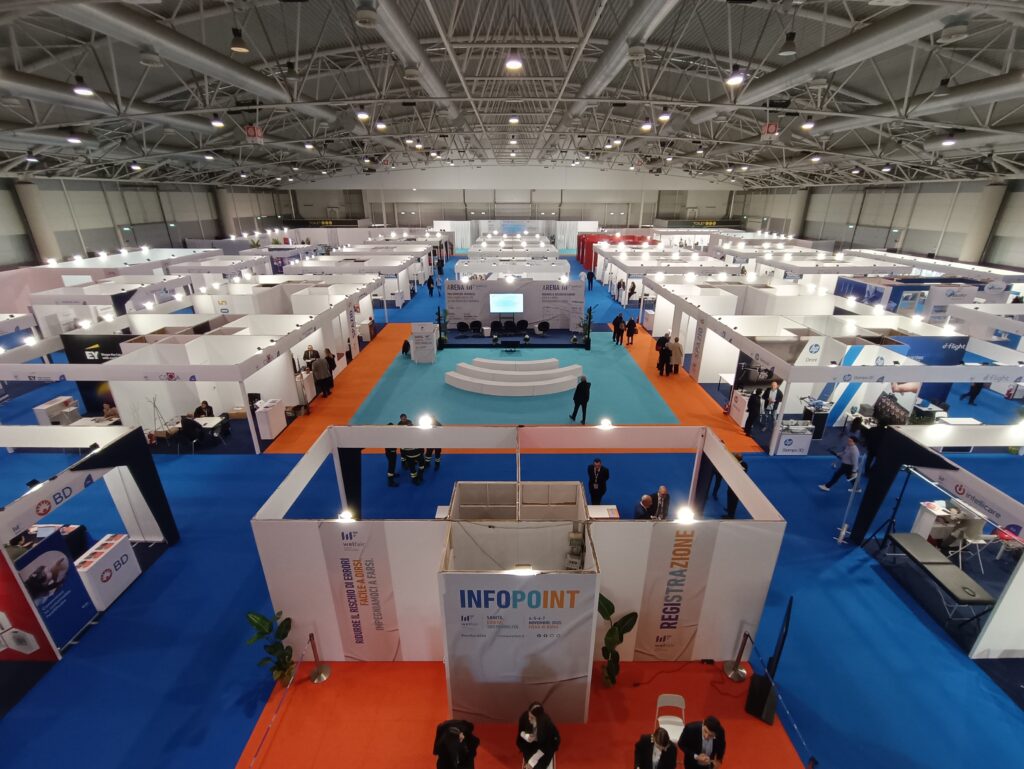 Panoramica dall'alto dello spazio espositivo di Welfair 2025 con stand, infopoint e area Arena al centro