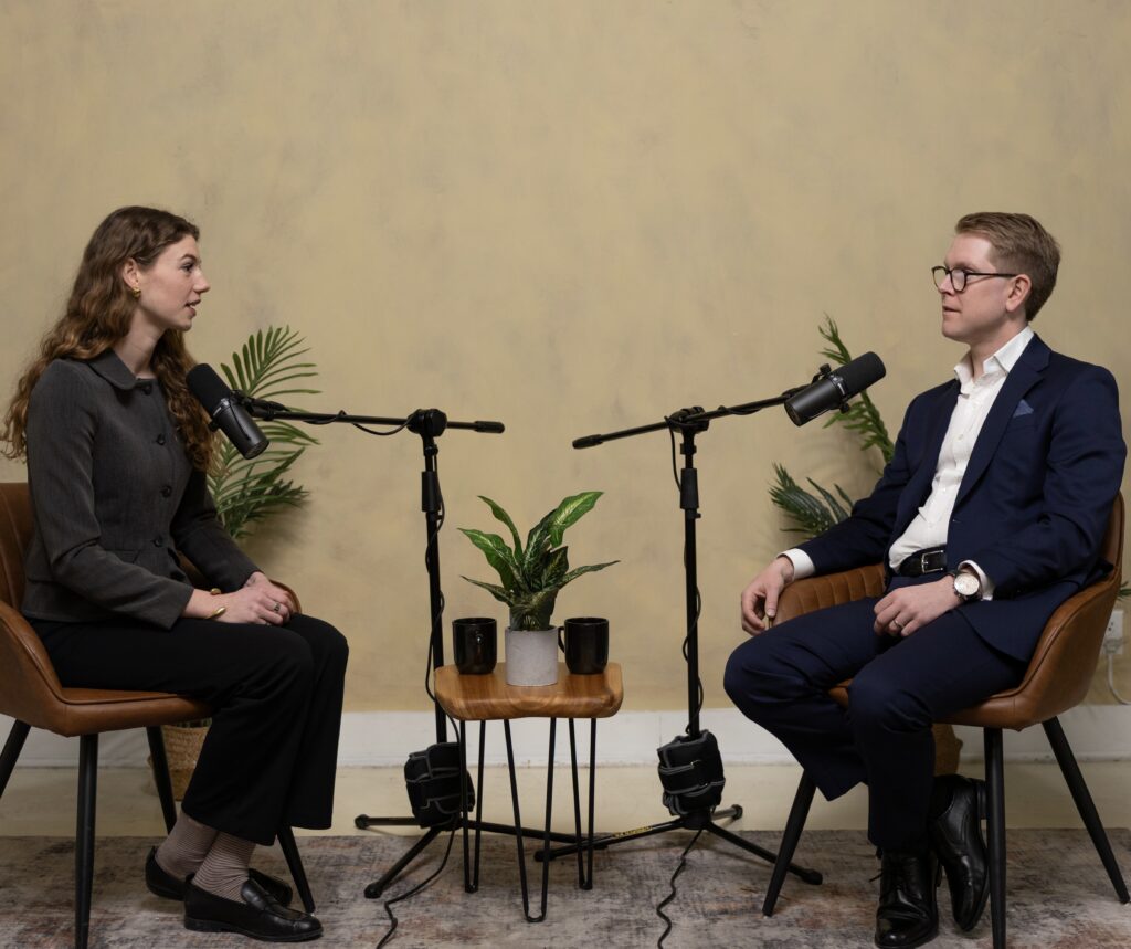 Due persone sedute una di fronte all'altra con microfoni su asta durante la registrazione di un'intervista Biomedical Bits